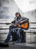 musician with a guitar sings on stage
