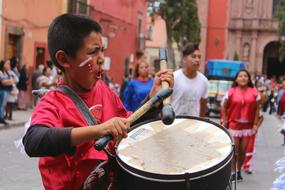 boy plays the drum on the street