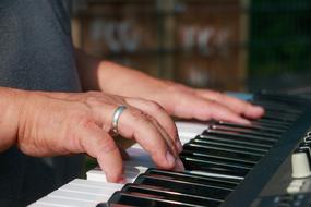 man fingering piano keys