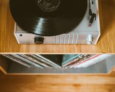Vinyl disk on turntable on shelf with disks
