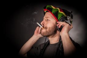 young caucasian man listening Music and Smoking Cigarette