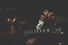 musician with a guitar in light and shadow