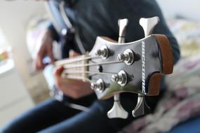 Person, playing on the beautiful, glossy bass guitar