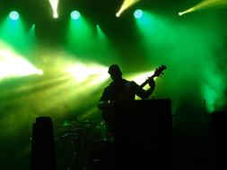 Musicians on the stage with the green lights on background