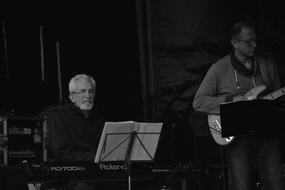 adult musicians on stage in black and white background