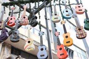 photo of multi-colored hanging guitars on the street in Chengdu