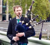 young man plays Bagpipes on street, uk, england, London