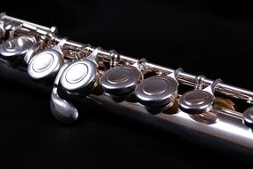 Shiny keys of Flute at black background