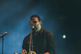 mature Man in front of stage microphone at darkness