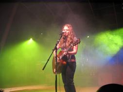 lead singer with guitar in colorful spotlights on stage