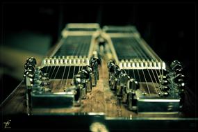 Close-up of the steel-guitar with the twenty strings, among the darkness