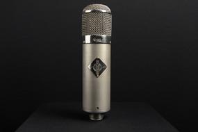 Close-up of the beautiful, shiny, retro "Neumann U47" microphone, at black background