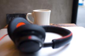 black audio headphones and a cup of coffee