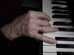 old hand on Piano key