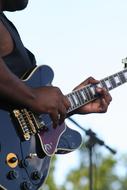 the hands of a guitarist standing on stage