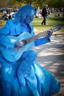 blue painted man plays Guitar in park