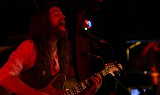 long haired young man, Rock Musician sings on concert