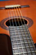 Close-up of the strings of the beautiful wooden guitar with ornament