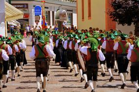 Music Band in traditional clothing marching on street in city, italy, south tyrol