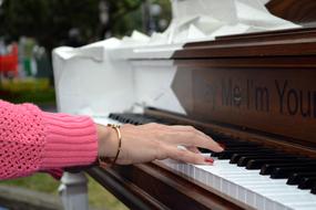 girl's hand with manicure on the keys of a piano