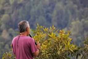 musician with flute among nature, back view