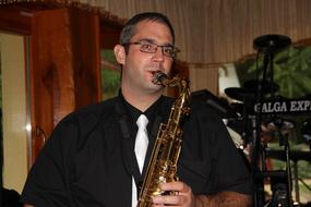 adult man plays Saksofon indoor