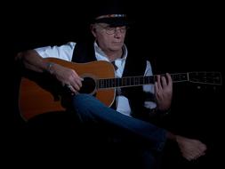 old guitar player in hat