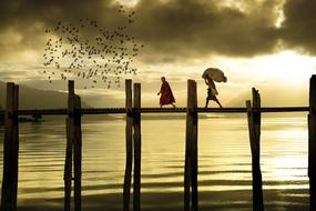 people on the bridge in the cloudy twilight