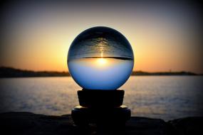 Sunset upside down in glass globe at dusk