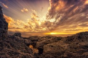 Beautiful landscape with the rocky coast, at colorful, gradient sunset on horizon