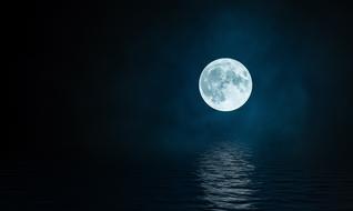 huge white moon reflected in water in the dark