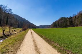 Beautiful landscape of the green valley in Krauchthal, Switzerland, among the trees and mountains, at blue sky on background
