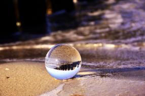 glass ball on the beach sand