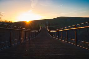 photo of suspension bridge against the background of dawn