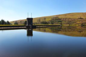 photo of a brick tower on the shore of a calm lake