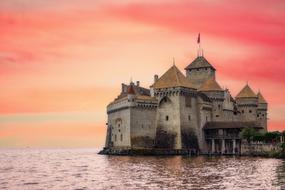 Beautiful landscape with the castle, among the water, at colorful, gradient sunset, in Switzerland