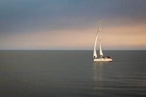 white sailboat on the ocean at dusk