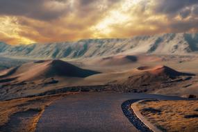 Beautiful highway going to volcanic mountains at beautiful and colorful sunset