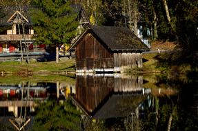 Beautiful landscape with the wooden hut, among the pond and green plants