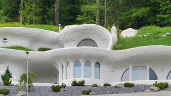 Beautiful, modern, white houses in the green hill with trees in Switzerland