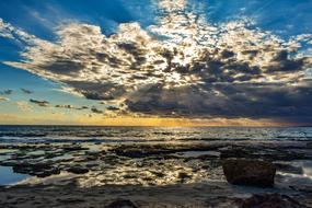 sun in dark clouds over the sea