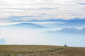 Beautiful and colorful panorama of the mountains, in clouds, from the Monte Lema, Switzerland, with the person