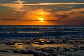 Beautiful sandy beach, and sea with the waves, in Ayia Napa, Cyprus, Greece, at colorful and beautiful sunset