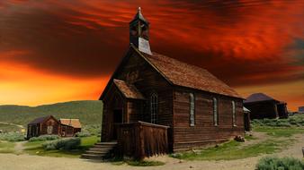 painted wooden church against a fire sky in California