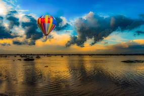 colorful hot air balloon above water at dusk in cyprus