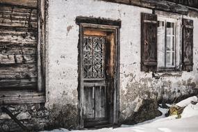 Beautiful, old, white house with the decorated door, among the snow, in winter