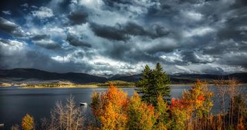 Beautiful landscape of the Lake Granby, among the colorful plants and mountains in Colorado, America, under the cloudy sky