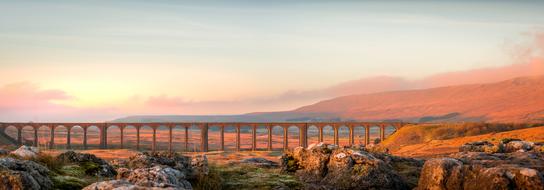 distant view of Ribblehead Viaduct at orange twilight