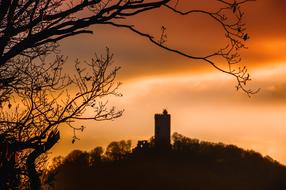 fortress on a hill against the orange sky