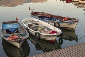 fishing boats on calm water near the pier at dusk